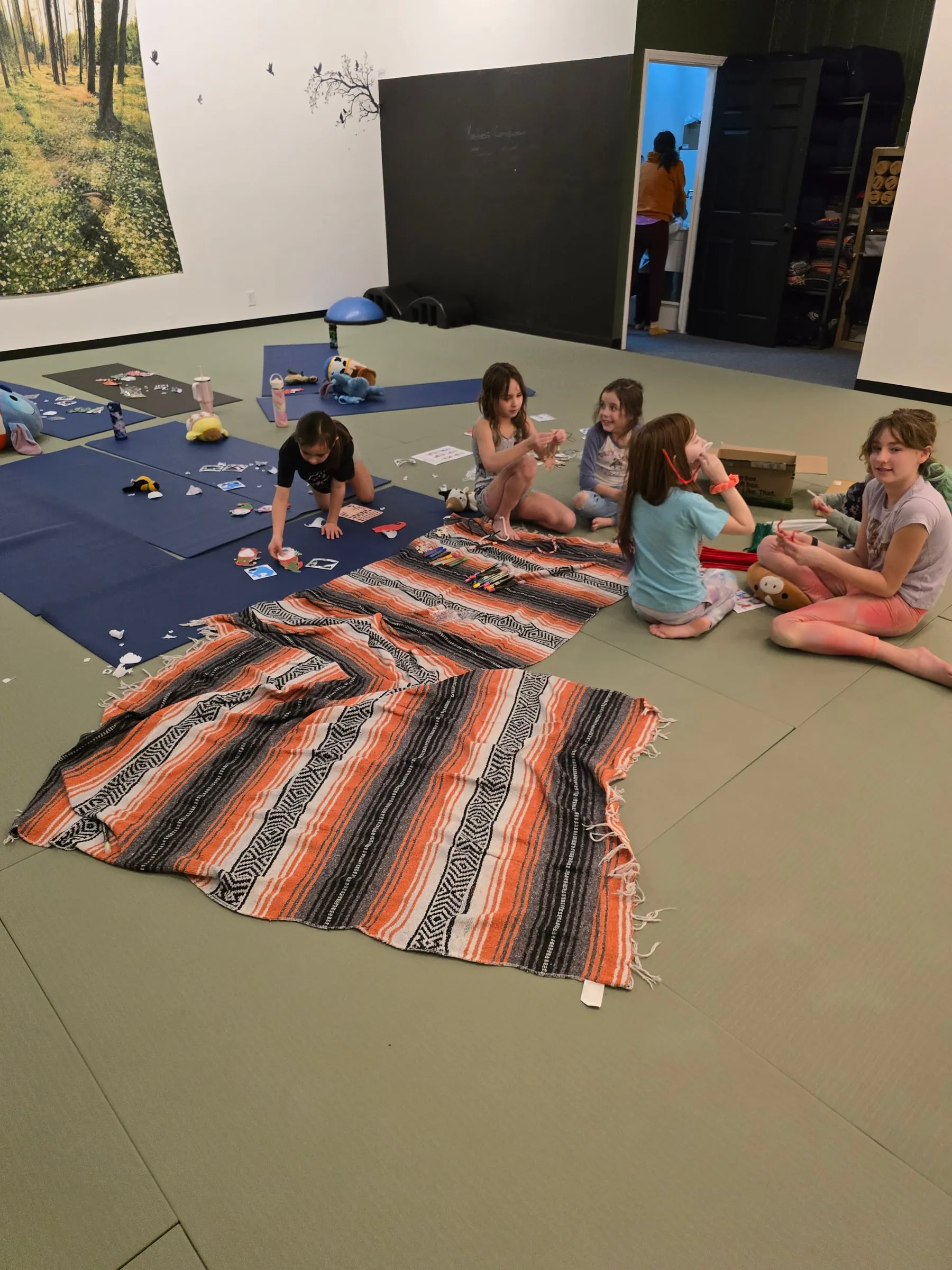 Children doing crafts together on blankets on the studio floor