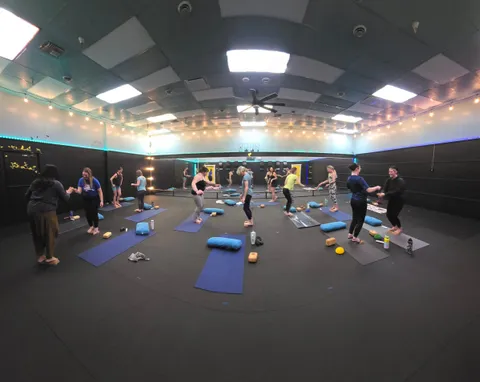 A full class stretching on mats in the studio